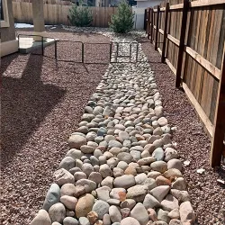 A dry bed river of rocks lining the edge or a property