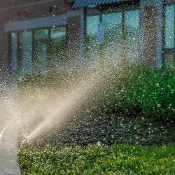 Automatic garden lawn sprinkler in action watering grass